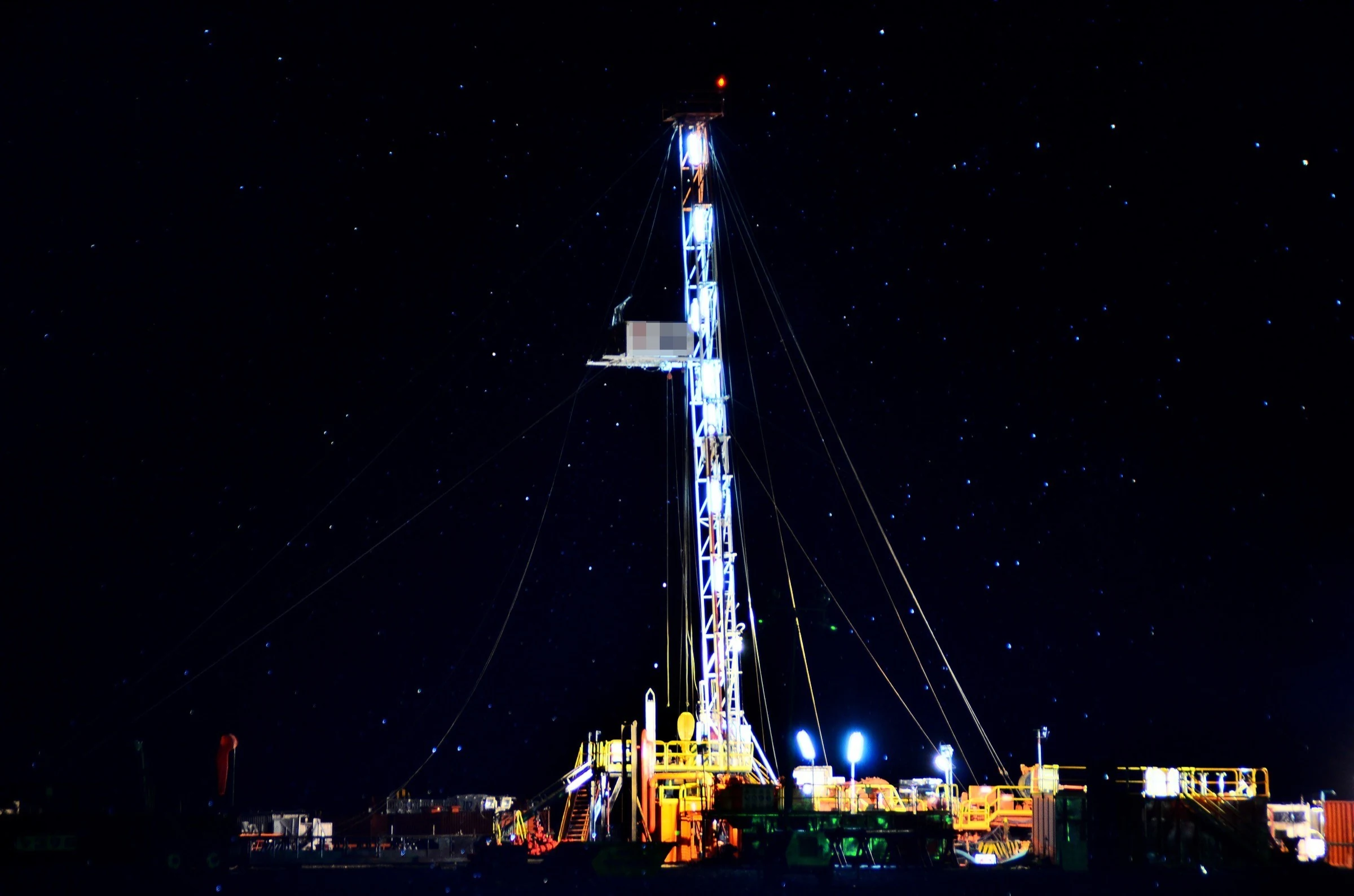 Illuminated drilling rig at night in Añelo, Patagonia